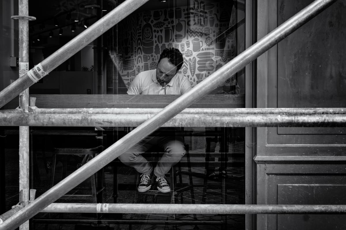 Homme au travail vu à travers des échafaudages